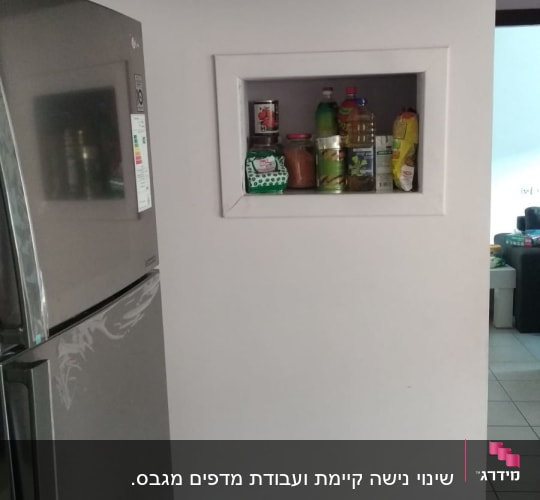 מוצרים על מדף גבס במטבח, כולל בקבוקים וצנצנות